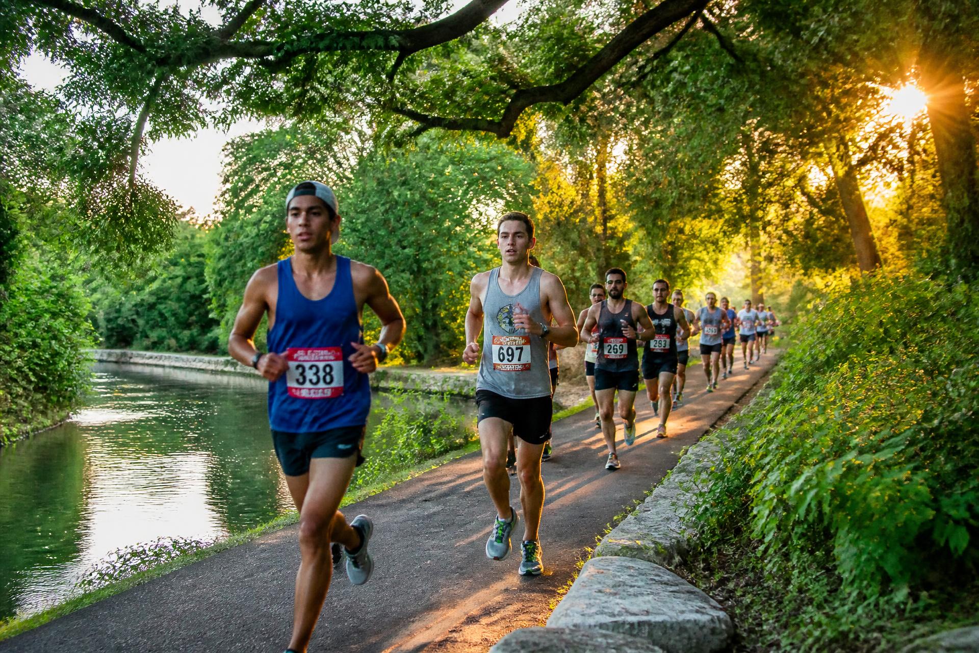 Runners racing on a shaded San Antonio trail